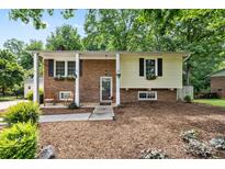 Charming two-story home with a mix of brick and siding, complemented by mature trees and flower boxes at 206 Pelham Ln, Fort Mill, SC 29715