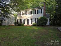 Charming two-story home featuring a classic colonial design, surrounded by lush greenery and mature trees at 2105 Killarney Pl, Charlotte, NC 28262