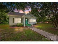 Charming single-story home with a quaint front porch, complemented by lush greenery and a serene atmosphere at 304 Miller Ave, Salisbury, NC 28144