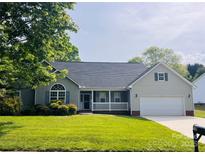 Charming single-story home featuring a covered porch, well-manicured lawn, and attached two-car garage at 318 Linsbury Ct, Gastonia, NC 28056