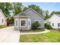 Charming home featuring a bay window, gray siding, and landscaped front yard at 509 W Sixth Ave, Gastonia, NC 28052
