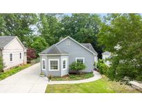 Charming gray home featuring a bay window, vinyl siding, manicured lawn and adjacent driveway at 509 W Sixth Ave, Gastonia, NC 28052
