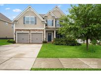 Charming two-story home featuring a well-manicured lawn, a two car garage and stone accents at 8347 Dallas Bay Rd, Charlotte, NC 28278
