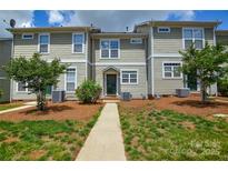 Inviting exterior of townhome featuring manicured lawn and walkway to front door at 105 Woodsong Ln, Mooresville, NC 28117