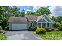 Charming home with blue and gray siding, a two-car garage, and mature landscaping, perfect for suburban living at 109 Gatwick Ct, Statesville, NC 28677