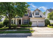 Charming two-story home featuring a brick facade, a two-car garage, and a beautifully landscaped front yard at 1458 Bedlington Nw Dr, Charlotte, NC 28269