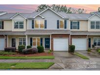 Charming townhouse with brick facade, garage, and well-maintained landscaping creates an inviting curb appeal at 15554 Stronvar House Ln, Charlotte, NC 28277