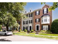 A row of townhomes showcases a blend of brick and siding, complemented by lush landscaping and a nearby car at 15623 Sir Charles Pl, Charlotte, NC 28277