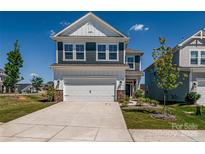 Frontal view of two-story house, featuring blue shutters, white trim, and two-car garage at 16042 River Tree Ln, Charlotte, NC 28278