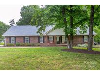 Charming brick home with a well-manicured lawn, mature trees, and inviting curb appeal at 1610 Ford St, Charlotte, NC 28216