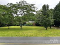 Expansive front yard featuring lush green lawn and mature trees, offering a serene and inviting curb appeal at 2009 Hickory Grove Rd, Gastonia, NC 28056