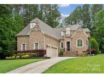 Charming brick home featuring a manicured lawn, two-car garage, and landscaped front yard at 309 Palm Cove Way, York, SC 29745