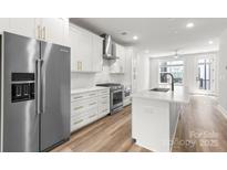 Bright, modern kitchen features stainless steel appliances, white cabinetry, and an island with bar seating at 4011 Tundra Rd, Charlotte, NC 28203