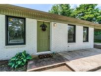 Charming home featuring a freshly painted, white brick exterior and an inviting green front door at 413 Picadilly Ln, Troutman, NC 28166