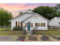 Charming exterior of home with white siding, blue front door, and fenced yard at 417 S Broad St, Gastonia, NC 28052