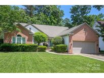 Charming brick home features a well-manicured lawn and established landscaping at 6009 Swanston Dr, Charlotte, NC 28269