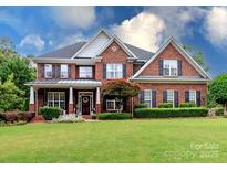 Beautiful two-story brick home featuring a manicured lawn and mature landscaping at 6202 Pumpernickel Ln, Wesley Chapel, NC 28110