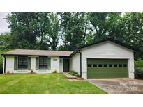 Charming single-story home with a green garage door and well-manicured lawn at 7228 Rollingridge Dr, Charlotte, NC 28211