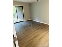 Bright bedroom with wood-look flooring and sliding glass doors leading to outdoor space at 8029 Cedar Glen Dr, Charlotte, NC 28212