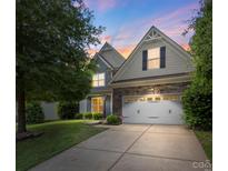 Charming home with a two-car garage, stone accents, and a well-maintained lawn at 9230 Loch Glen Way, Charlotte, NC 28278
