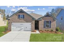 Charming brick home features a two-car garage, blue shutters, and well-manicured lawn at 9924 Manor Vista Trl, Kannapolis, NC 28027