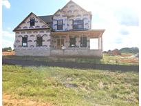 New home construction featuring brick foundation and covered porch awaiting finishing touches at Lot 100 Coppergate Dr, Salisbury, NC 28147