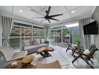 Bright sunroom features an outdoor view, modern furniture, unique wood decor, and ample natural light at 11216 Preservation Ln, Charlotte, NC 28278