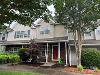 Traditional townhome showcasing a brick front, cozy porch, and tidy landscaping enhancing curb appeal at 12238 Paperbark Cir, Charlotte, NC 28277