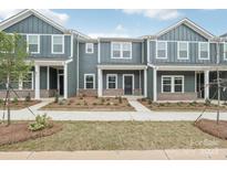 Modern townhome with blue siding, white trim, and well-manicured landscaping provides excellent curb appeal at 124 Utility Ln # B, Mooresville, NC 28117