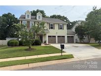 Inviting two-story home featuring a three-car garage and well-manicured lawn at 12517 Pine Terrace Ct, Charlotte, NC 28273