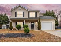 Lovely two-story home with a manicured lawn, mature trees, and an attached garage at 130 Valley Glen Dr, Troutman, NC 28166