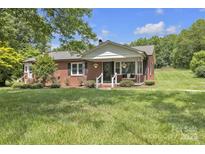 Charming brick home with a cozy front porch and beautifully landscaped front yard at 1770 Nc 90 W Hwy, Taylorsville, NC 28681