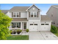 Charming two-story home featuring a welcoming front porch and a two-car garage at 2104 New Hope Branch Way, Belmont, NC 28012