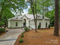 Stunning white home featuring beautiful landscaping, driveway and attached garage at 21404 Blakely Shores Dr, Cornelius, NC 28031
