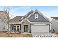 Charming single-Gathering home with blue siding, stone accents, and a two-car garage at 219 Tillery Ln # 755, Mount Gilead, NC 27306