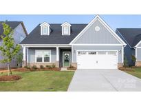 Charming single-story home featuring light blue siding, dormer windows, green front door and a two-car garage at 219 Tillery Ln # 755, Mount Gilead, NC 27306