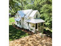 Beautiful two-story home featuring a white exterior, metal roof, manicured lawn, and landscaped yard at 2268 New Gray Rock Rd, Fort Mill, SC 29708