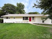 Charming single-story home with a red front door, brick accents, and a well-manicured lawn at 2469 Elkwood Cir, Charlotte, NC 28205