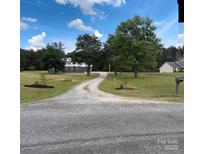 Long gravel driveway leading to a charming home on a lush green lawn under a blue sky with scattered clouds at 330 Skyview Dr, Catawba, SC 29704