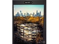 A building construction site with a skyline view showcases progress and urban development at 409 Queens Rd # 401, Charlotte, NC 28207