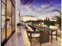 A stylish outdoor dining area offers city skyline views at sunset, with seating for eight on a spacious terrace at 409 Queens Rd # 401, Charlotte, NC 28207