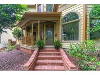 Charming front door with brick steps and decorative porch, plants, and large arched window at 416 E Park Ave, Charlotte, NC 28203
