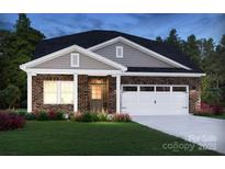 Charming brick home featuring a covered porch, two-car garage, and well-maintained landscaping at 417 Bent Burr Crk, York, SC 29745