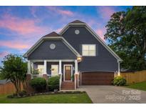Charming home showcasing a well-manicured lawn, covered porch with columns, and attached garage at 516 King St, Waxhaw, NC 28173