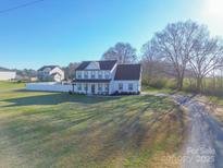 A two-story home with white siding, black trim, a lawn, a driveway and mature trees at 5413 Austin Rd # 4, Monroe, NC 28112
