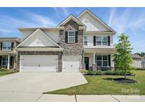 Beautiful two-story home with a three-car garage, stone accents, manicured lawn and stylish curb appeal at 6416 Willow Pin Ln, Huntersville, NC 28078
