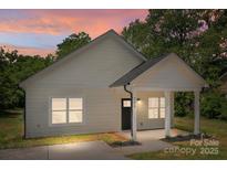 Charming home featuring a covered porch with white columns and beautiful sunset sky at 706 Live Oak St, Shelby, NC 28150