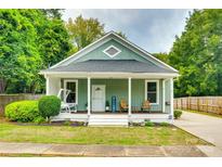 Charming home featuring a covered porch with swing, wood chairs, and a manicured lawn at 8 Cauthen St, Rock Hill, SC 29730