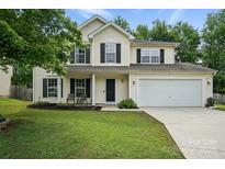 Inviting two-story home features a well-manicured lawn, attached garage, and classic design elements at 8381 Chatsworth Dr, Indian Land, SC 29707