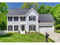 Beautiful two-story home with a well-manicured lawn, black shutters, and a two-car garage at 1134 Blueberry Ln, Charlotte, NC 28226